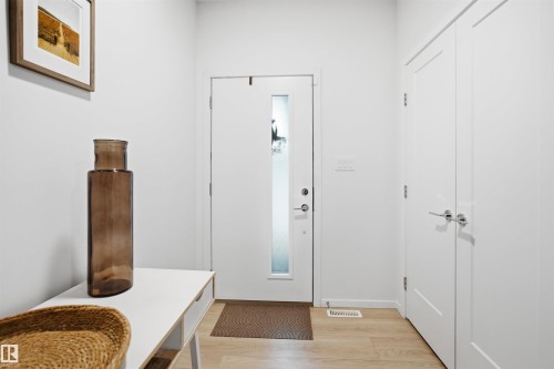 Entryway featuring a white door with a frosted glass insert, light wood-finish flooring, and white walls - 7782 174A Avenue, Edmonton, AB - Indoor Photo Showing Other Room