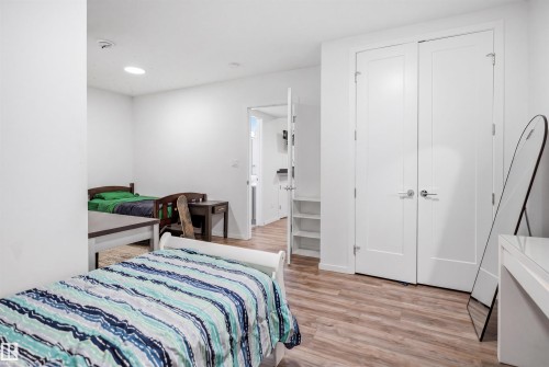 Room featuring wood-finish flooring, white walls, and a double-door closet with polished chrome hardware - 7782 174A Avenue, Edmonton, AB - Indoor Photo Showing Bedroom