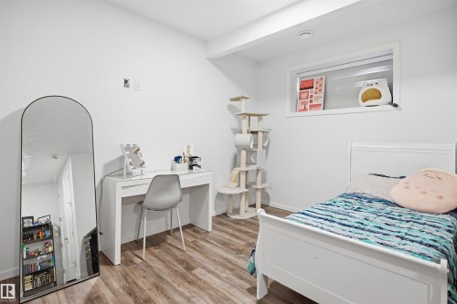 Bright room featuring wood-finish flooring, a contemporary window, and white walls - 7782 174A Avenue, Edmonton, AB - Indoor Photo Showing Bedroom