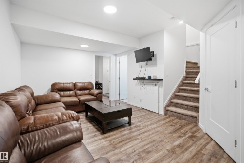 Open living area featuring wood-finish flooring, recessed lighting, and a neutral color palette - 7782 174A Avenue, Edmonton, AB - Indoor