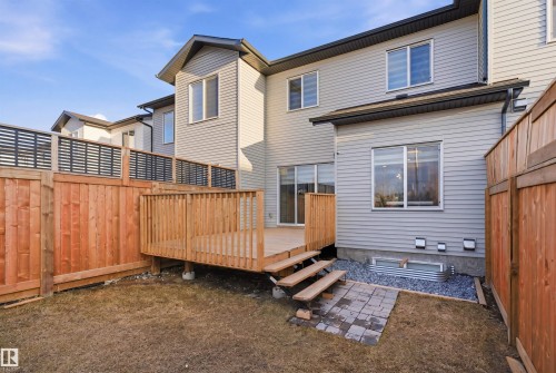 Private backyard featuring a wooden deck with railing, a multi-level privacy fence, and a ground-level patio area - 7782 174A Avenue, Edmonton, AB - Outdoor With Exterior