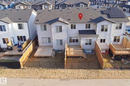 Rear exterior featuring light-colored siding and a dark shingle roof - 7782 174A Avenue, Edmonton, AB - Outdoor
