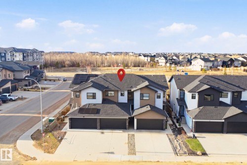 Contemporary duplex featuring a dark shingle roof and contrasting facade elements - 7782 174A Avenue, Edmonton, AB - Outdoor With Facade