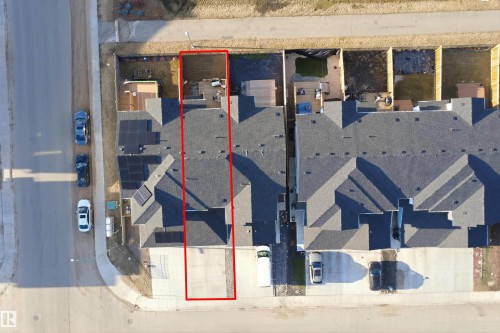 Aerial perspective showcasing a property with a paved driveway, a detached garage, and a rear deck - 7782 174A Avenue, Edmonton, AB - 