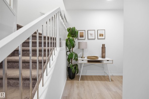 Staircase with carpeted treads and white handrail featuring metal balusters - 7782 174A Avenue, Edmonton, AB - Indoor Photo Showing Other Room