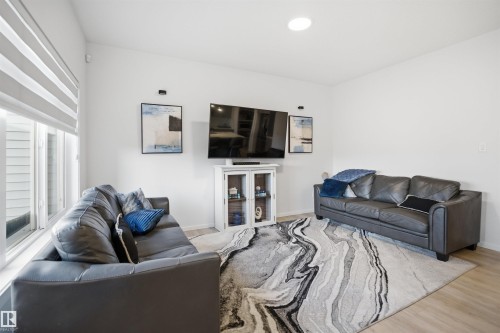 Bright living area featuring wood-finish flooring and white walls - 7782 174A Avenue, Edmonton, AB - Indoor Photo Showing Living Room
