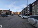 Multi-story residential buildings featuring varied siding materials including dark panels, red accents, and sage green panels - 206 12045 22 Avenue, Edmonton, AB  - Outdoor 