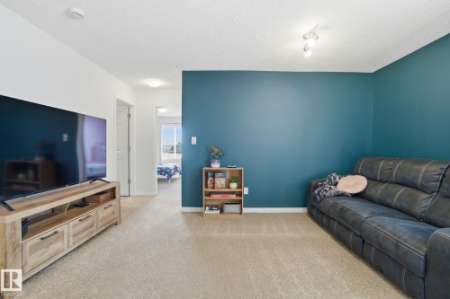The property features carpeted flooring, a ceiling with recessed lighting, and a wall painted in a rich blue hue - 2553 Coughlan Road, Edmonton, AB - Indoor Photo Showing Other Room