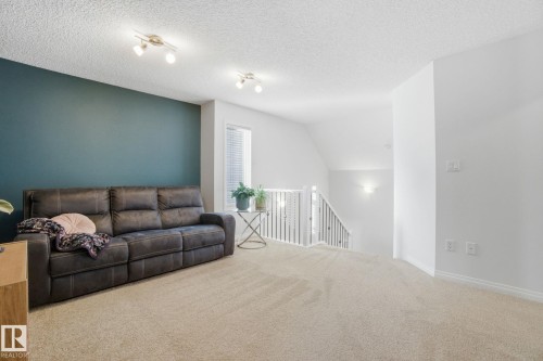 This bright space features light-colored carpeting, a partial accent wall, and a window with blinds - 2553 Coughlan Road, Edmonton, AB - Indoor