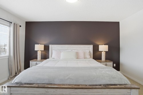 This bedroom features a dark accent wall, complementing the white walls and white trim - 2553 Coughlan Road, Edmonton, AB - Indoor Photo Showing Bedroom