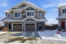 The property features a two-story exterior with a combination of grey siding and white trim, along with a two-car garage - 2553 Coughlan Road, Edmonton, AB  - Outdoor With Facade 
