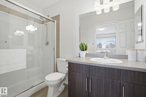 Bathroom featuring a glass-enclosed shower, a toilet, a vanity with an undermount sink, and a large mirror - 2553 Coughlan Road, Edmonton, AB - Indoor Photo Showing Bathroom
