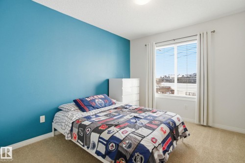 The room features a carpeted floor and a window with blinds and curtains - 2553 Coughlan Road, Edmonton, AB - Indoor Photo Showing Bedroom
