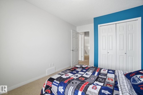 This room features light-colored carpeting, a white paneled closet, and a white door with a silver-toned doorknob - 2553 Coughlan Road, Edmonton, AB - Indoor Photo Showing Bedroom