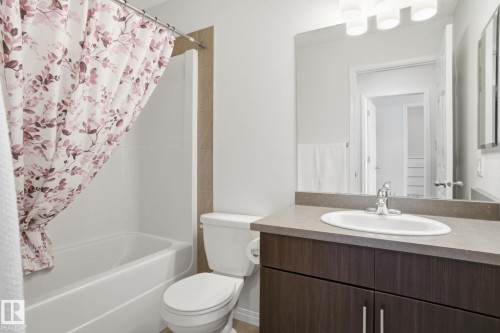 The bathroom features a white tub and shower combination with a tiled surround - 2553 Coughlan Road, Edmonton, AB - Indoor Photo Showing Bathroom