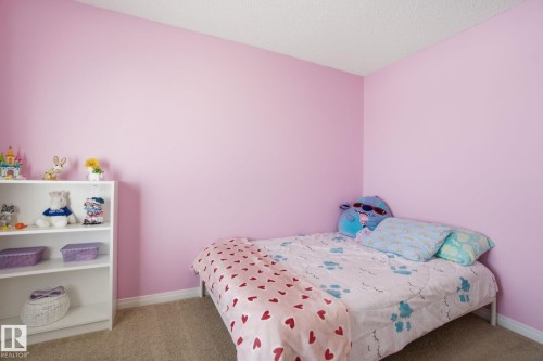 This room features pink walls and neutral carpeting, creating a versatile aesthetic - 2553 Coughlan Road, Edmonton, AB - Indoor Photo Showing Bedroom
