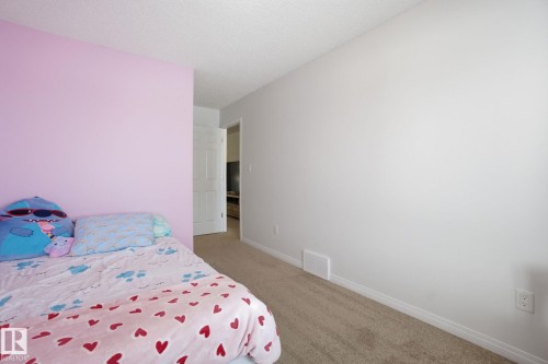 This room features carpeted flooring and walls painted in two different colors, with a white baseboard trim - 2553 Coughlan Road, Edmonton, AB - Indoor Photo Showing Bedroom