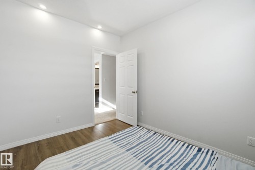 This room features light-colored walls, recessed ceiling lights, and wood-style flooring - 2553 Coughlan Road, Edmonton, AB - Indoor