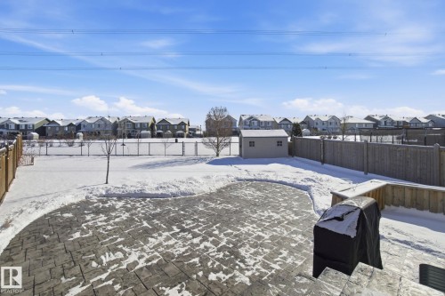 The property features a spacious backyard with a patterned paved patio and a detached storage shed - 2553 Coughlan Road, Edmonton, AB - Outdoor