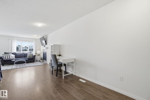 Bright living area featuring hardwood flooring, white walls, and a large window providing natural illumination - 2553 Coughlan Road, Edmonton, AB - Indoor