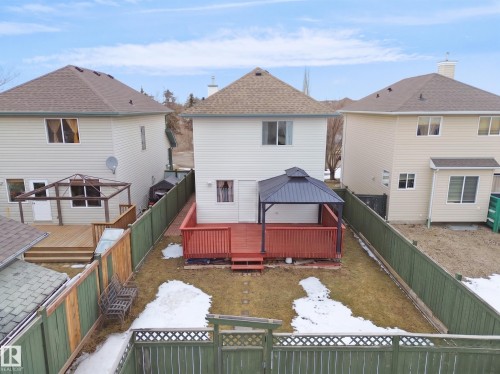 Expansive backyard featuring a red-stained wooden deck, a dark-roofed gazebo, and a green privacy fence - 21379 89 Avenue Nw, Edmonton, AB - Outdoor With Deck Patio Veranda With Exterior