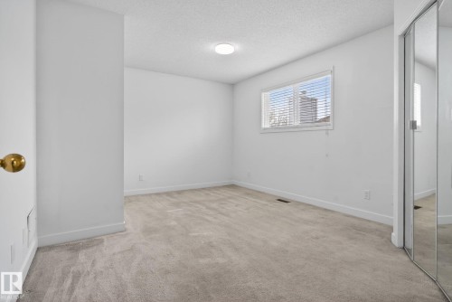 Bright interior space featuring light-toned carpet flooring, white walls, and a textured ceiling - 18604 97A Avenue, Edmonton, AB - Indoor Photo Showing Other Room