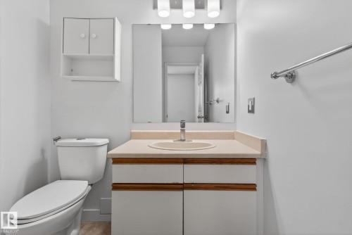 Bathroom vanity with an integrated sink, light-toned countertop, and wood-finish accent trim - 18604 97A Avenue, Edmonton, AB - Indoor Photo Showing Bathroom