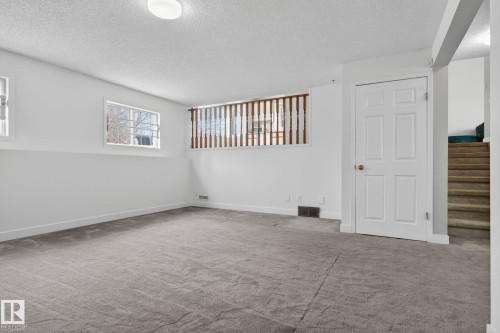 Expansive lower-level space featuring light gray carpeting, white walls, and two visible windows - 18604 97A Avenue, Edmonton, AB - Indoor Photo Showing Other Room
