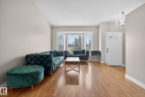 Spacious living area featuring wood-finish flooring, a prominent bay window, and neutral wall tones - 18604 97A Avenue, Edmonton, AB - Indoor Photo Showing Living Room