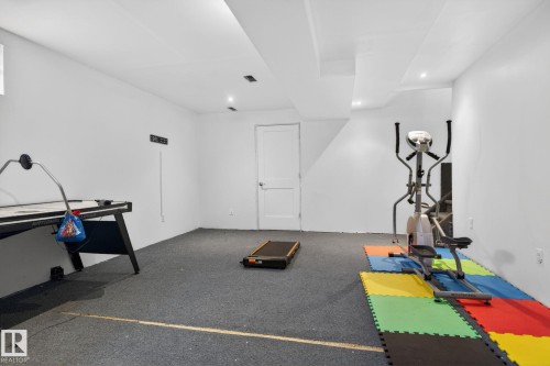Spacious room featuring light-colored walls, recessed ceiling lighting, and dark grey carpet flooring - 18604 97A Avenue, Edmonton, AB - Indoor Photo Showing Gym Room