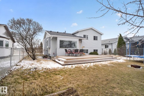 Rear exterior featuring light-colored siding, a multi-level wood deck, and a bay window - 18604 97A Avenue, Edmonton, AB - Outdoor With Deck Patio Veranda
