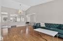 Spacious living area featuring vaulted ceilings, wood-finish flooring, neutral wall tones, a decorative chandelier, and a pass-through wall opening - 18604 97A Avenue, Edmonton, AB  - Indoor Photo Showing Living Room 