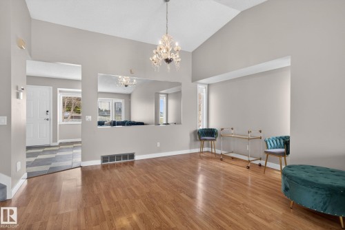 Spacious living area featuring wood-finish flooring, a vaulted ceiling, and a prominent chandelier - 18604 97A Avenue, Edmonton, AB - Indoor Photo Showing Other Room