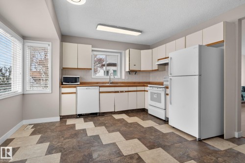 Kitchen featuring white cabinetry, light wood-finish countertops, and a white tile backsplash - 18604 97A Avenue, Edmonton, AB - Indoor Photo Showing Kitchen