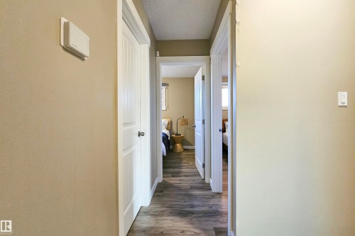 Hallway featuring wood-finish flooring, light tan wall paint, and white trim - 4203 83 Street, Edmonton, AB - Indoor Photo Showing Other Room