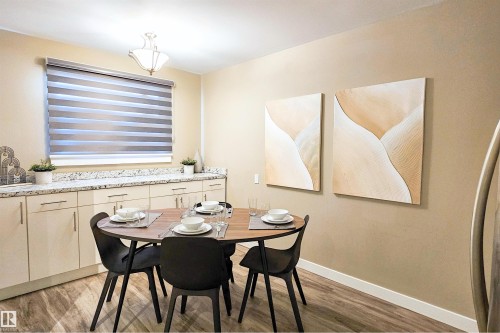 Dining area featuring wood-finish flooring and a contemporary chandelier - 4203 83 Street, Edmonton, AB - Indoor Photo Showing Dining Room