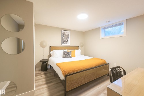 Bedroom featuring wood-finish flooring, a wall-mounted light fixture, a window with blinds, and a built-in overhead light - 4203 83 Street, Edmonton, AB - Indoor Photo Showing Bedroom
