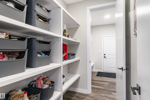 Expansive pantry featuring multiple white built-in shelves and wood-finish flooring - 2 Edison Drive, St. Albert, AB - Indoor With Storage
