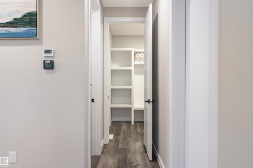 Hallway with wood-finish flooring and light neutral wall paint - 2 Edison Drive, St. Albert, AB - Indoor Photo Showing Other Room