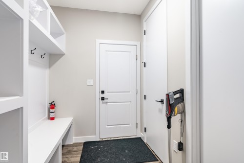 Entryway mudroom featuring built-in white cabinetry, integrated bench seating, and wall-mounted hooks - 2 Edison Drive, St. Albert, AB - Indoor Photo Showing Other Room
