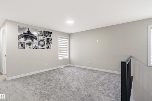 Spacious carpeted room featuring a window with horizontal blinds, neutral wall tones, and recessed ceiling lighting - 2 Edison Drive, St. Albert, AB - Indoor Photo Showing Other Room