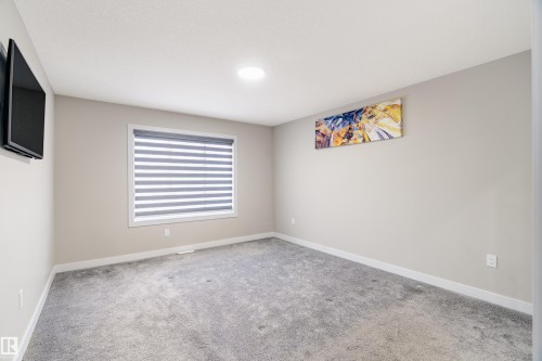 Spacious room featuring neutral wall tones, grey carpeting, a large window with horizontal blinds, and a built-in ceiling light - 2 Edison Drive, St. Albert, AB - Indoor Photo Showing Other Room
