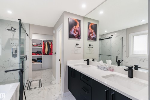 Bathroom with a dual vanity featuring dark cabinetry, white countertops, and matte black fixtures - 2 Edison Drive, St. Albert, AB - Indoor Photo Showing Bathroom