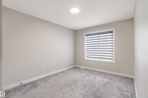 Interior room featuring gray carpet flooring, light neutral-toned walls, and white baseboards - 2 Edison Drive, St. Albert, AB - Indoor Photo Showing Other Room