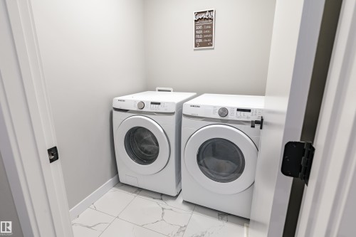 Dedicated laundry area featuring a front-loading washer and dryer set - 2 Edison Drive, St. Albert, AB - Indoor Photo Showing Laundry Room