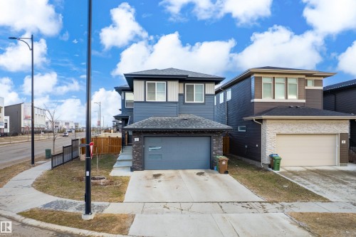 Contemporary two-story home featuring a dark blue siding facade, a single-car garage, and a concrete driveway - 2 Edison Drive, St. Albert, AB - Outdoor With Facade