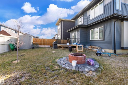 Spacious backyard with a paver-stone fire pit area, a built-in outdoor grill, and a wooden deck - 2 Edison Drive, St. Albert, AB - Outdoor With Exterior