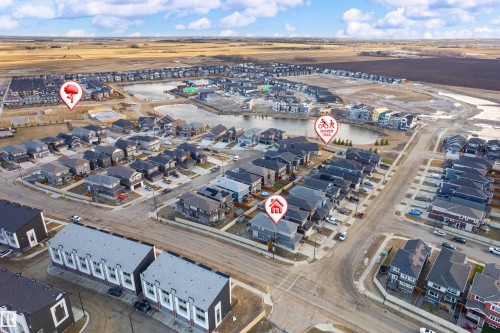 Aerial perspective of a developed residential area featuring a central retention pond and surrounding homes - 2 Edison Drive, St. Albert, AB - Outdoor With View