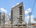 High-rise building featuring a textured facade, multiple private balconies, and ground-level commercial spaces - 701 10135 116 Street Nw, Edmonton, AB  - Outdoor With Facade 
