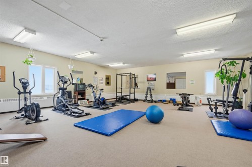 Dedicated fitness room featuring cardio machines, weight training equipment, and open floor space - 701 10135 116 Street Nw, Edmonton, AB - Indoor Photo Showing Gym Room